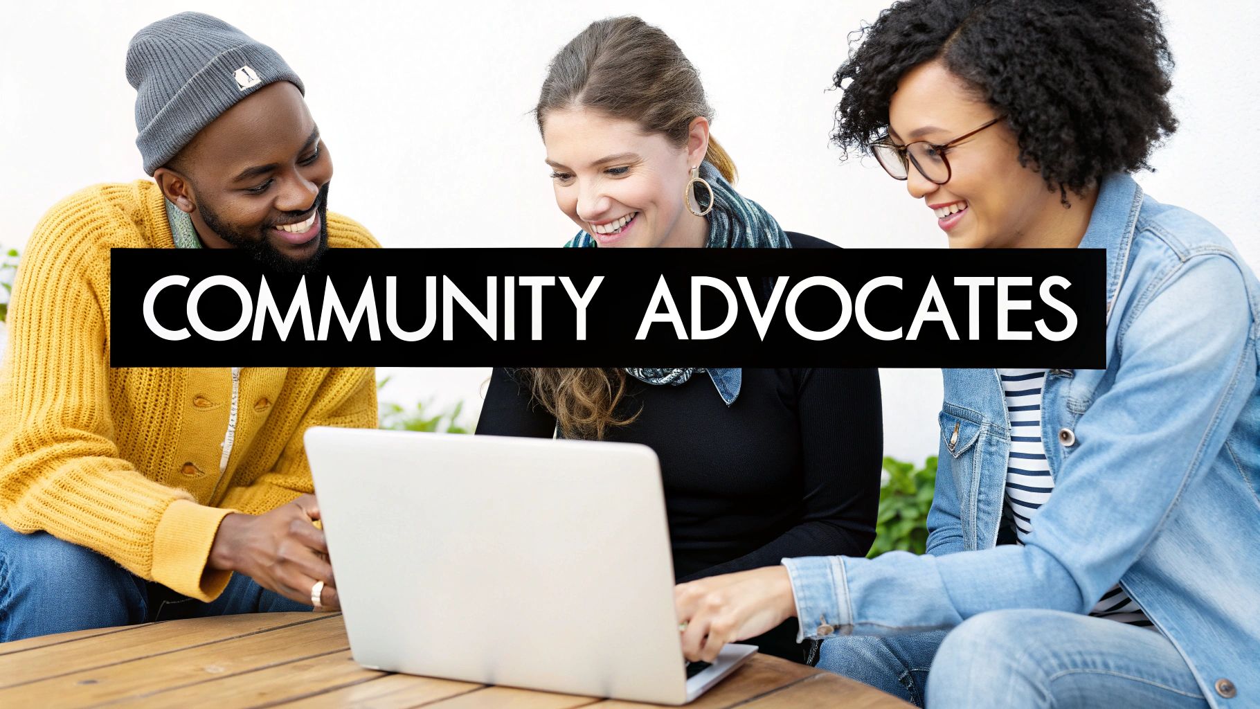 Three diverse people smiling and collaborating around a laptop, with "COMMUNITY ADVOCATES" text.