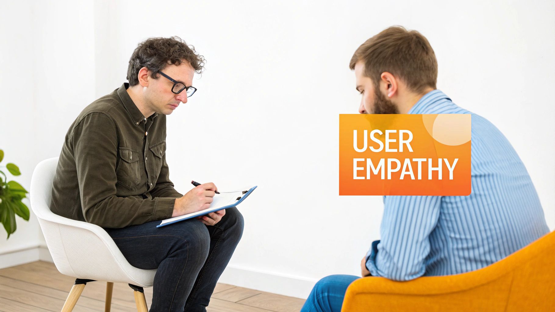 A man takes notes while interviewing another, with a 'USER EMPATHY' graphic overlay.