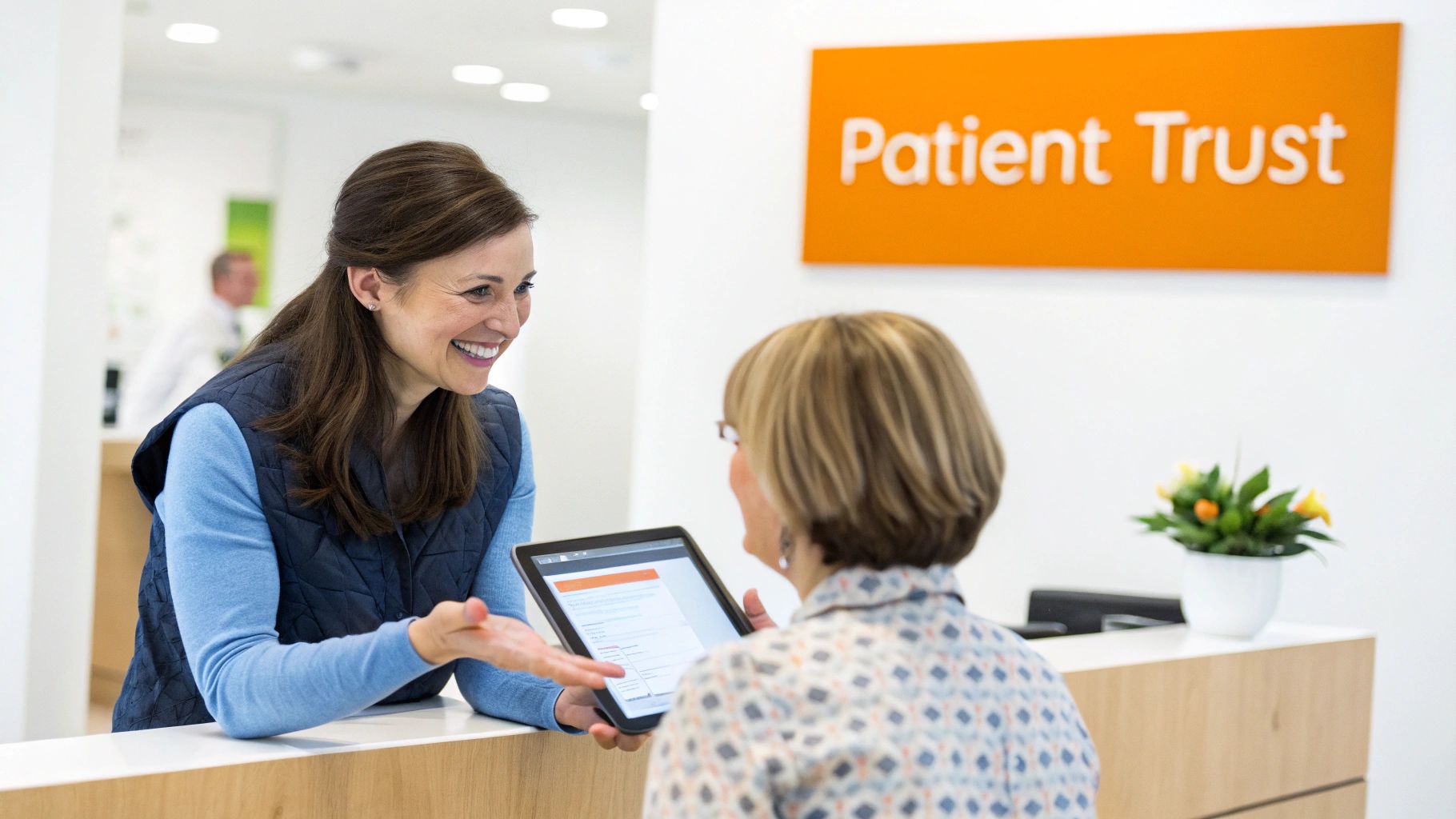 Smiling medical professional guides patient at reception desk using a digital tablet for information.