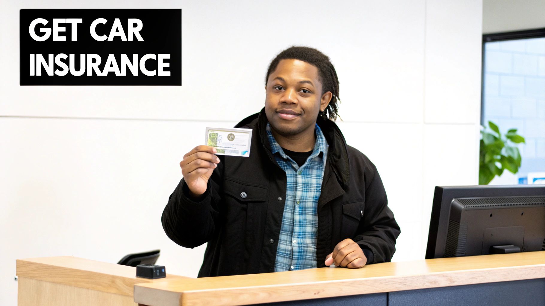 A smiling young Black man holds up a document at a counter next to a "GET CAR INSURANCE" sign.