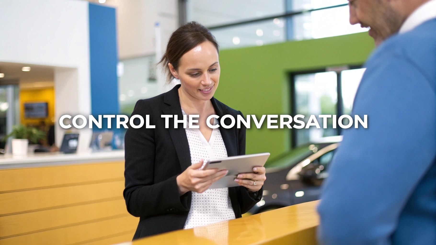 A customer and a car salesperson having a calm, professional conversation in a modern dealership showroom.