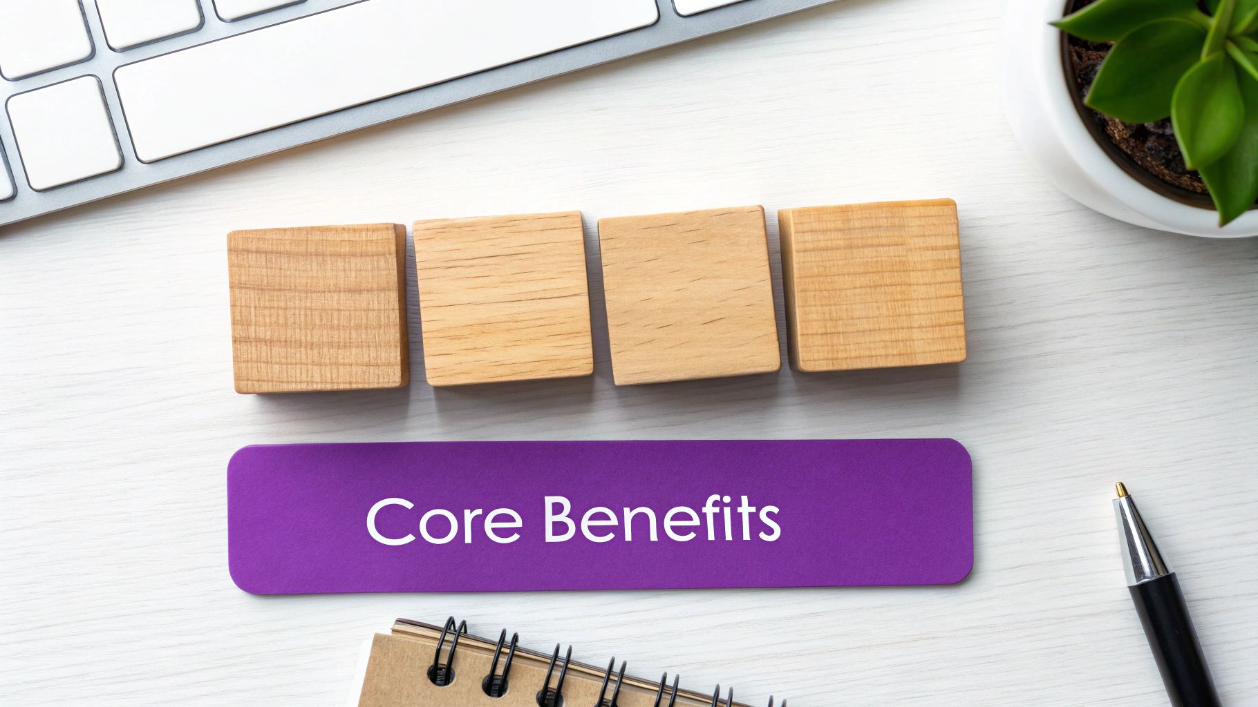 Overhead desk view with a keyboard, plant, and a purple card displaying 'Core Benefits' with wooden blocks.