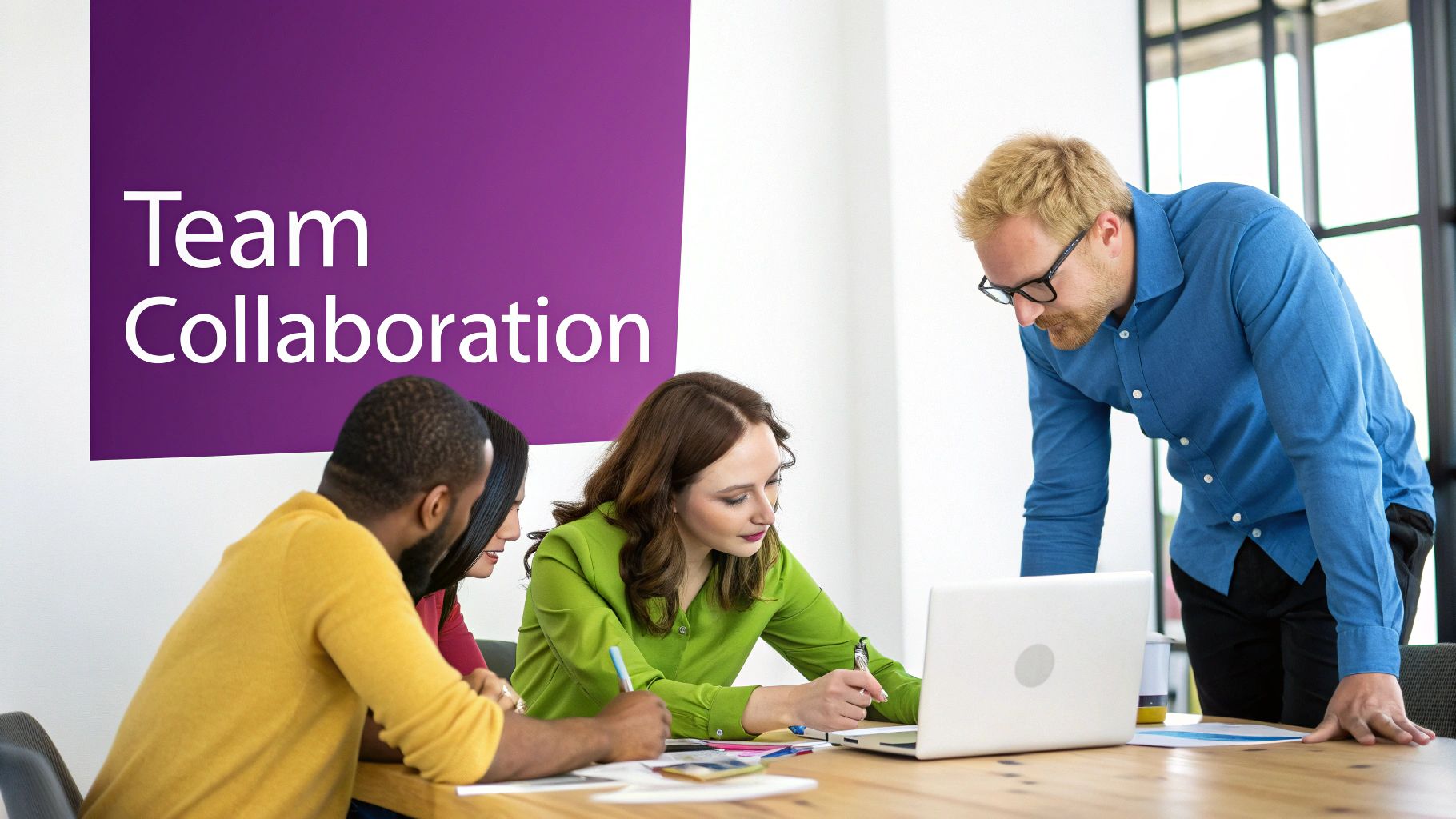 Diverse team of professionals actively collaborating at a meeting table with a laptop and documents.