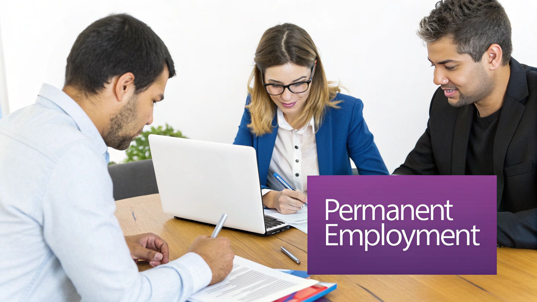 Three professionals discuss permanent employment, working on documents and a laptop at a table.