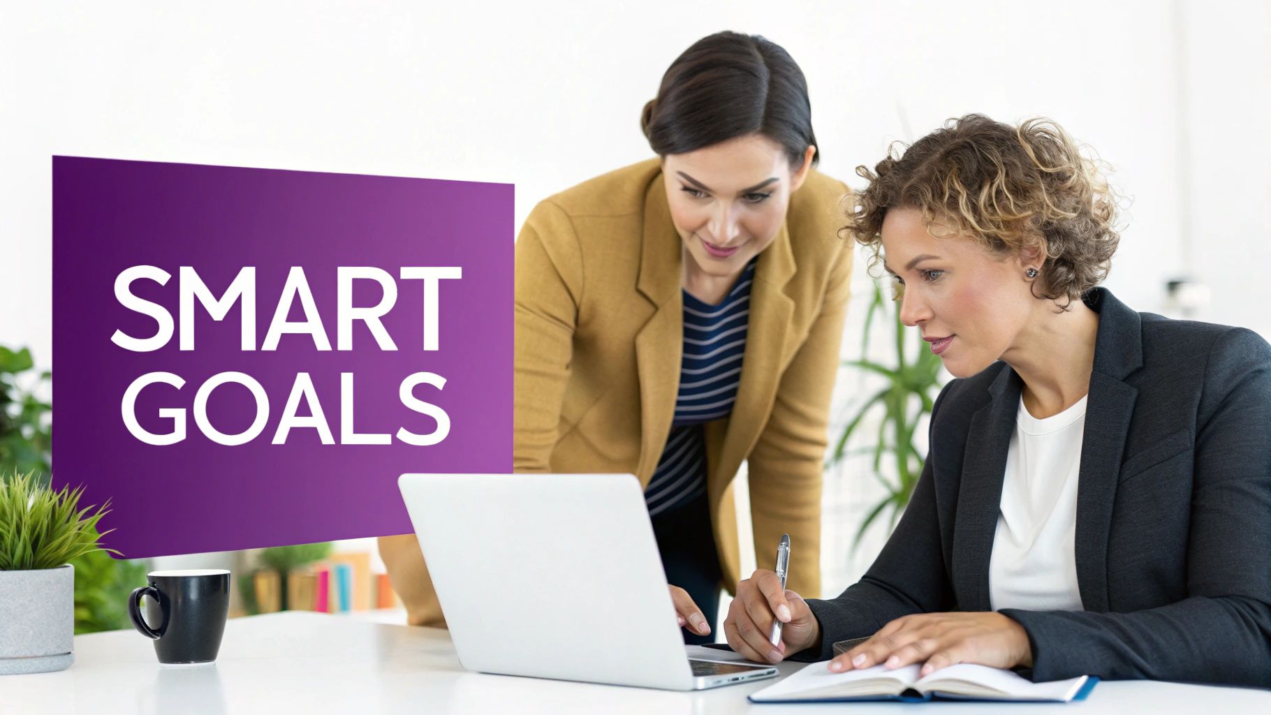 Two professional women collaborate on a laptop and notebook, with a 'SMART GOALS' sign in the background.