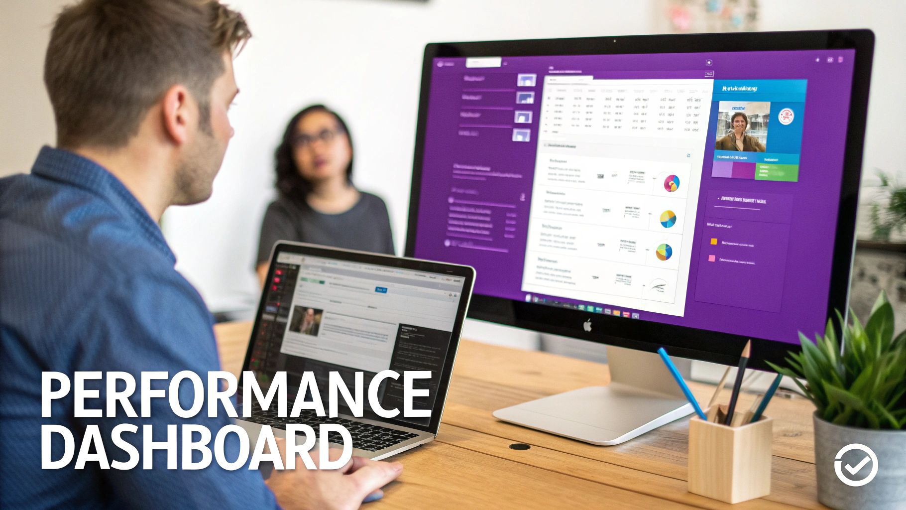 A man views a performance dashboard on a laptop and desktop monitor in an office setting.
