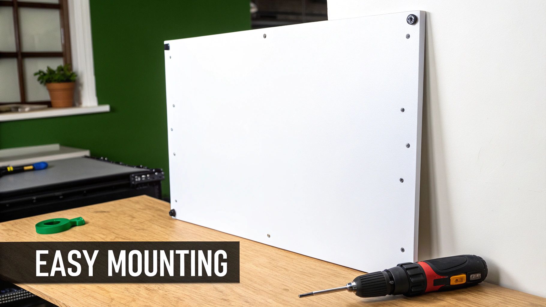 White board with screws on a wooden table next to a screwdriver, indicating easy mounting.