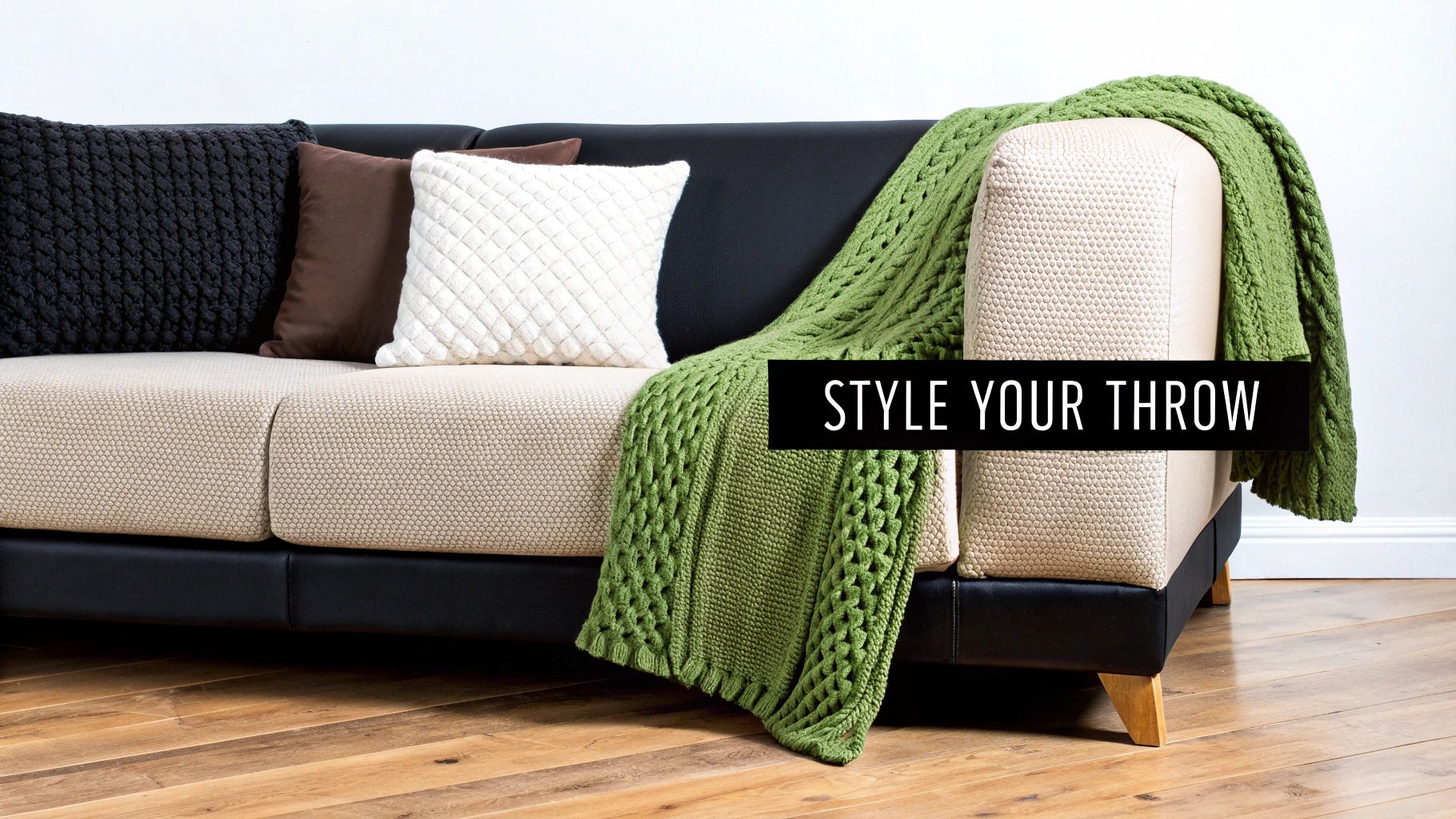 A beautifully styled sofa with a neutral-coloured throw elegantly draped over it.