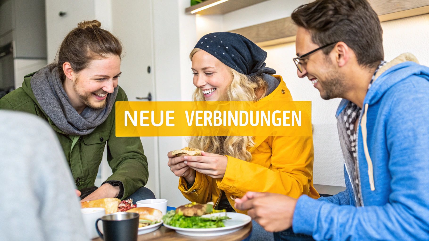 Eine Gruppe junger Backpacker lacht und unterhält sich in einer belebten Hostelküche, was Gemeinschaft und soziale Interaktion symbolisiert.