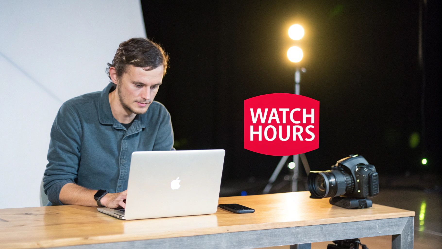 A man works on a laptop at a studio table with a camera, alongside a "WATCH HOURS" graphic.