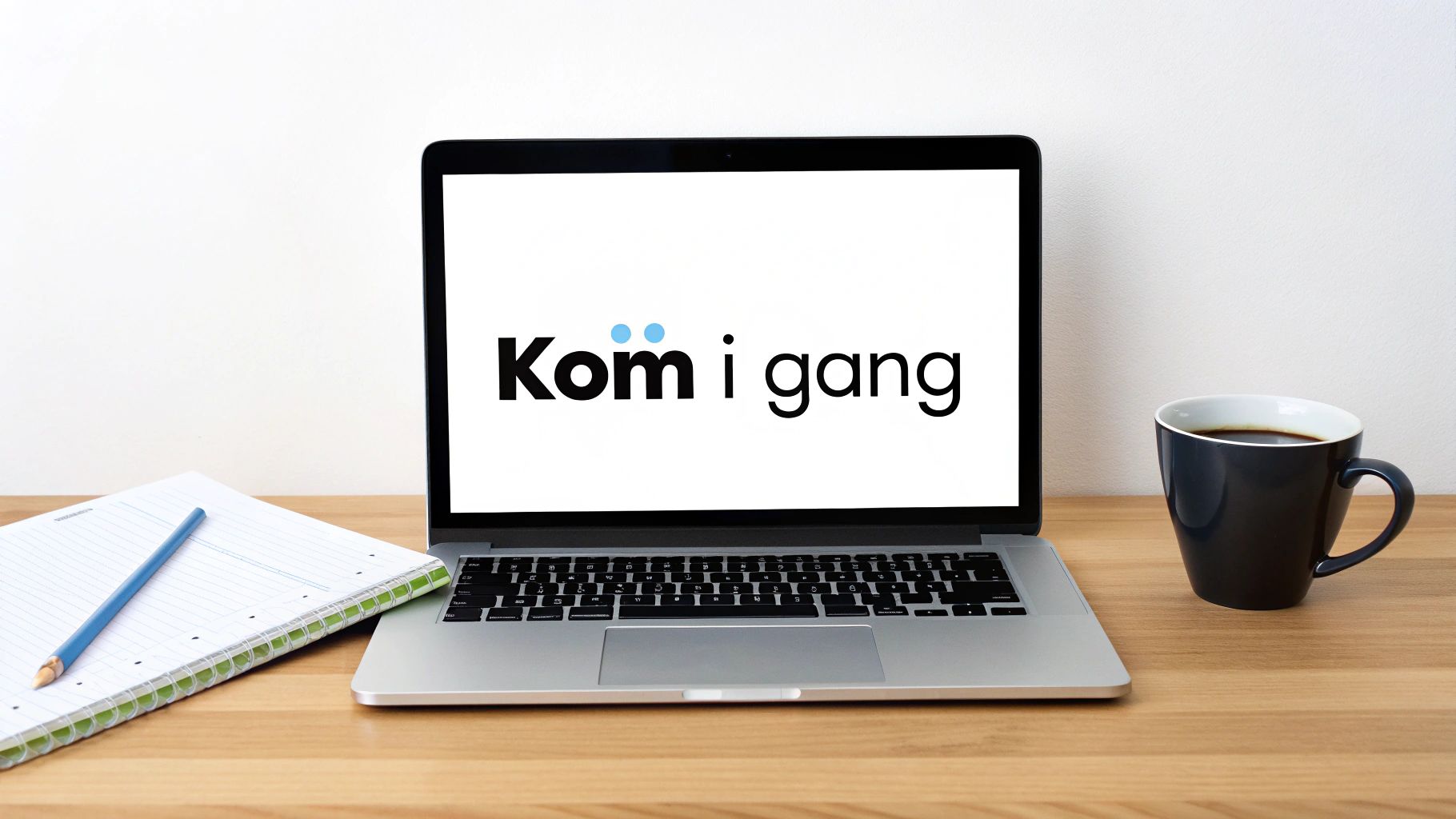 En åpen laptop på et skrivebord viser teksten 'Kom i gang', med en notatbok og kaffe.