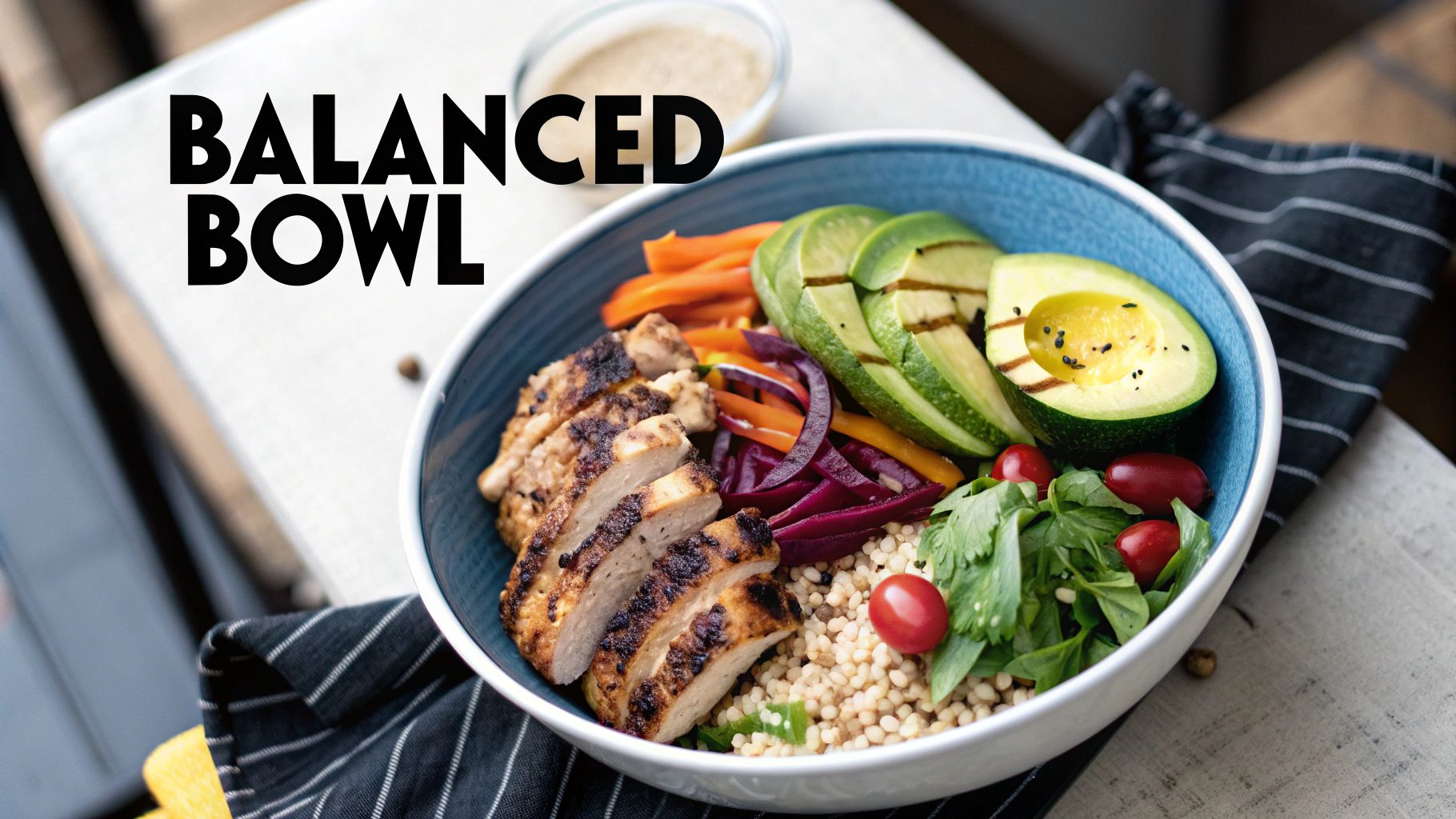 A healthy balanced bowl featuring grilled chicken, sliced avocado, couscous, and fresh vegetables.