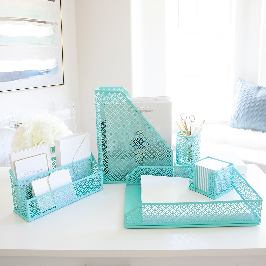 A collection of matching turquoise desk organizers with a geometric pattern, on a bright white desk.