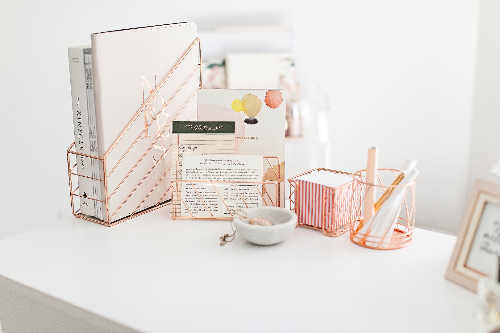 Aesthetic desk setup with rose gold office supplies, including a file holder, note stand, and pen holder.