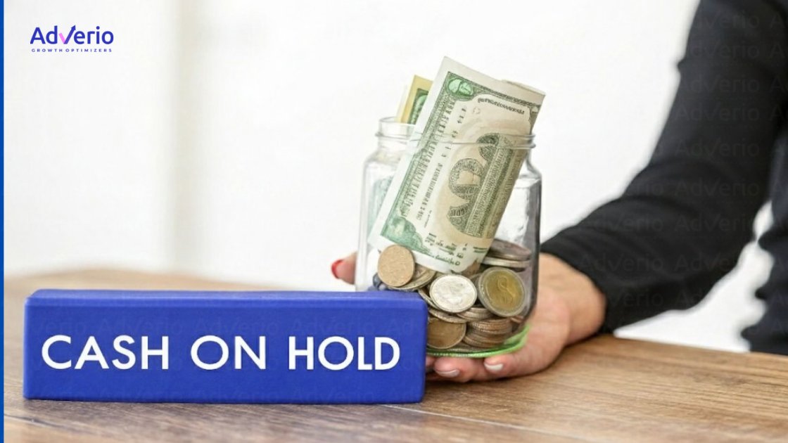 A person holds a jar of coins and banknotes next to a blue block saying "CASH ON HOLD."
