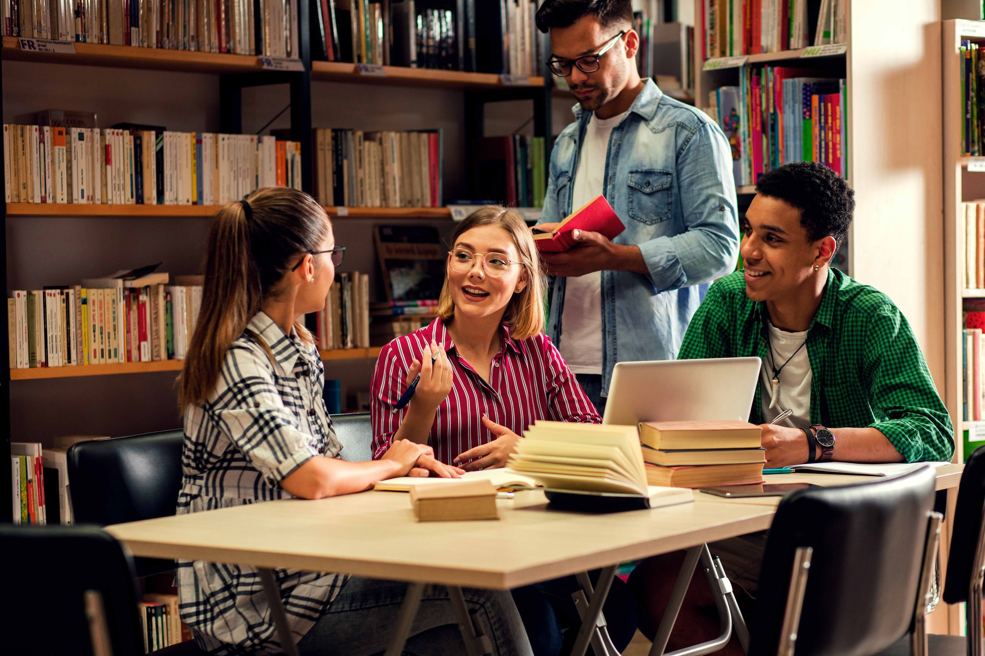 Students writing in a vocabulary journal with a textbook open next to them.