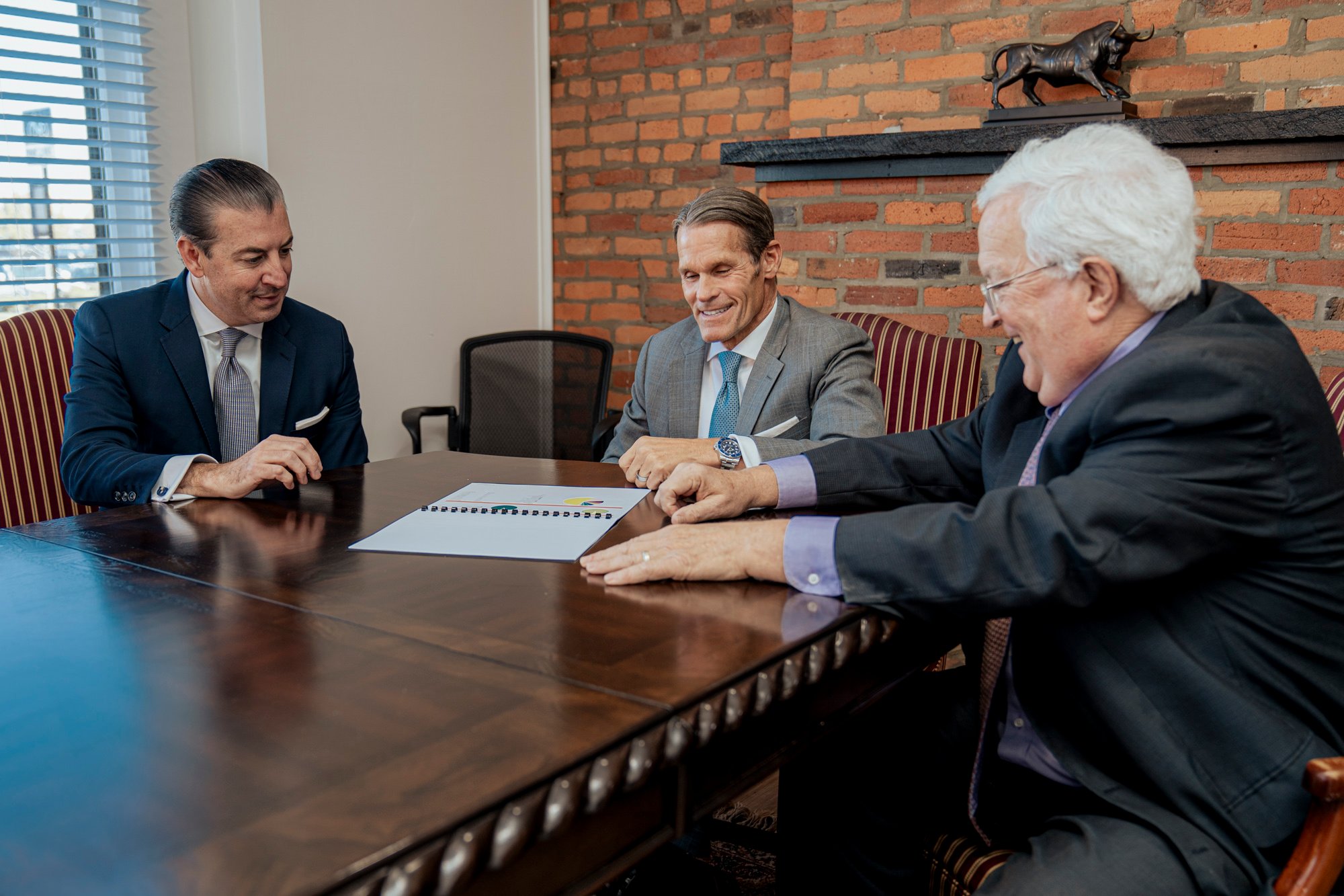 Our three most experienced team members around a large wooden table.