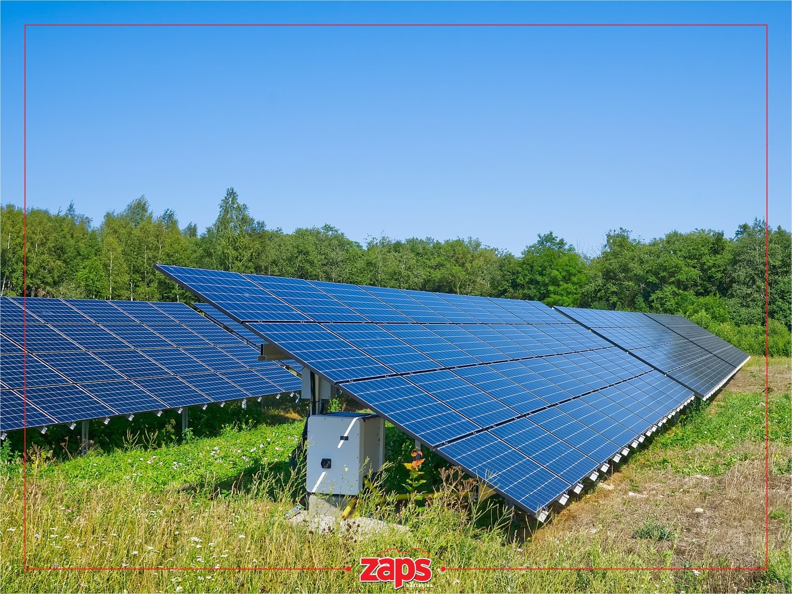 Φωτοβολταϊκά πάνελ σε καταπράσινο χωράφι κάτω από έναν καθαρό μπλε ουρανό, παράγοντας καθαρή ενέργεια.