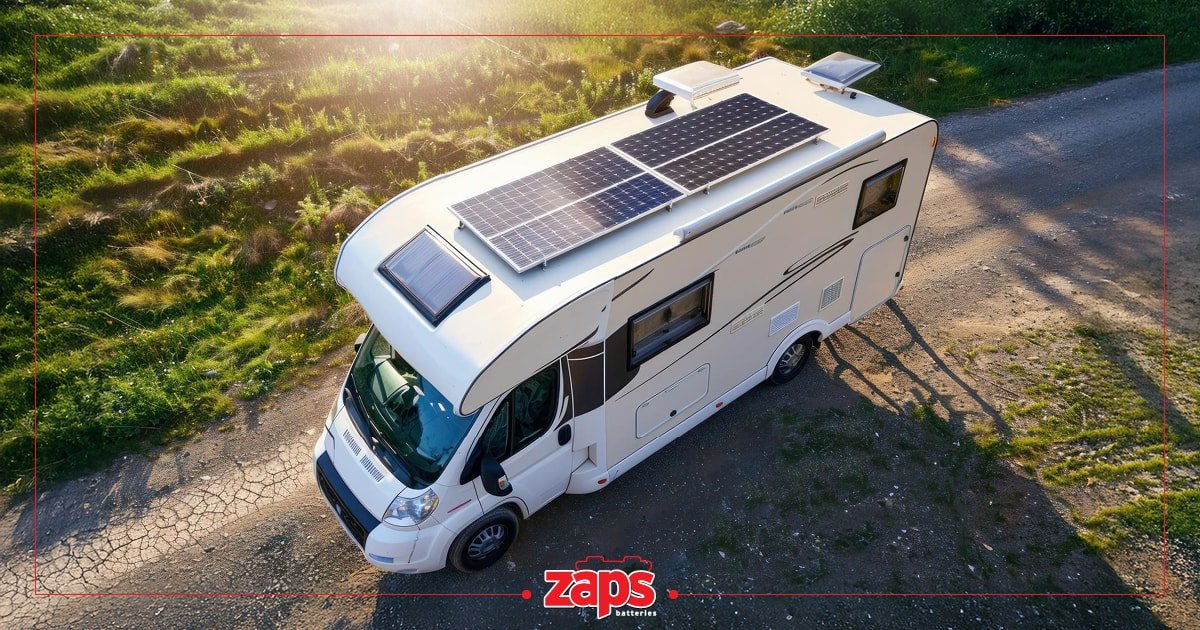 Ένα λευκό τροχόσπιτο με ηλιακά πάνελ στην οροφή, παρκαρισμένο σε χωματόδρομο δίπλα σε καταπράσινο τοπίο κάτω από τον ήλιο.