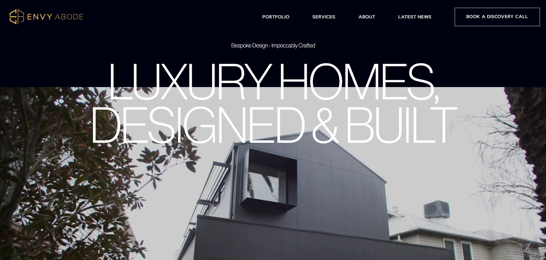 A modern dark luxury home with large white text overlay 'LUXURY HOMES, DESIGNED & BUILT' and 'ENVY ABODE' logo.