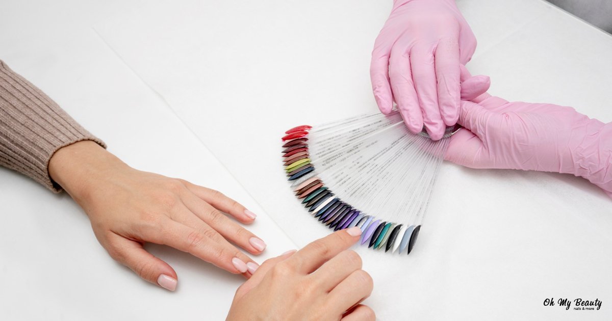 Ημιμόνιμο Μανικιούρ: Ο Πλήρης Οδηγός για το 2025 Τεχνικός νυχιών με ροζ γάντια δείχνει παλέτα χρωμάτων ημιμόνιμου μανικιούρ σε πελάτισσα