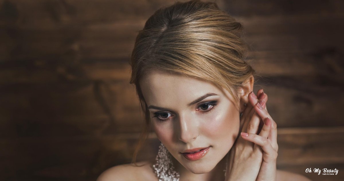 Ρομαντικό Νυφικό Μακιγιάζ: Ο Απόλυτος Οδηγός για το 2026 Μια γυναίκα με ρομαντικό μακιγιάζ, αψεγάδιαστο δέρμα και κομψό χτένισμα, με τα χέρια της κοντά στο αυτί της.