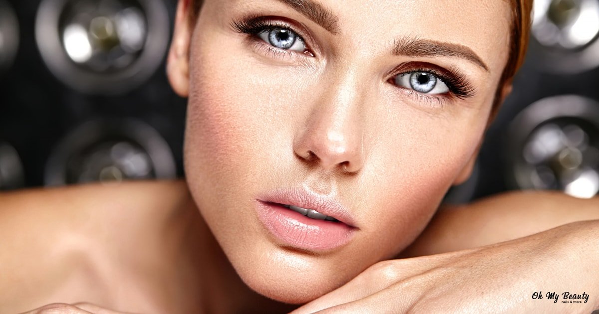 Lash lift οδηγίες: τέλειες βλεφαρίδες με διάρκεια Κοντινό πλάνο ενός όμορφου γυναικείου προσώπου με έντονα βλέφαρα και χείλη, που στηρίζεται στο χέρι της.