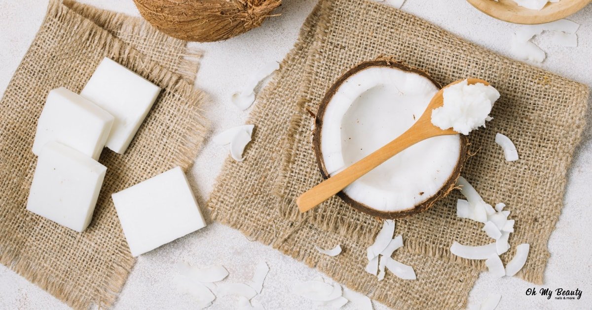 Λάδι Καρύδας στο Πρόσωπο: Ο Απόλυτος Οδηγός Ομορφιάς Εικόνα με λάδι καρύδας σε ξύλινο κουτάλι, μισή καρύδα, νιφάδες και λευκά σαπούνια σε λινάτσα.