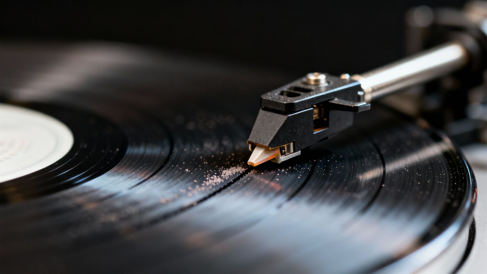 Close-up of a turntable's phono stylus resting on a dusty black vinyl record.