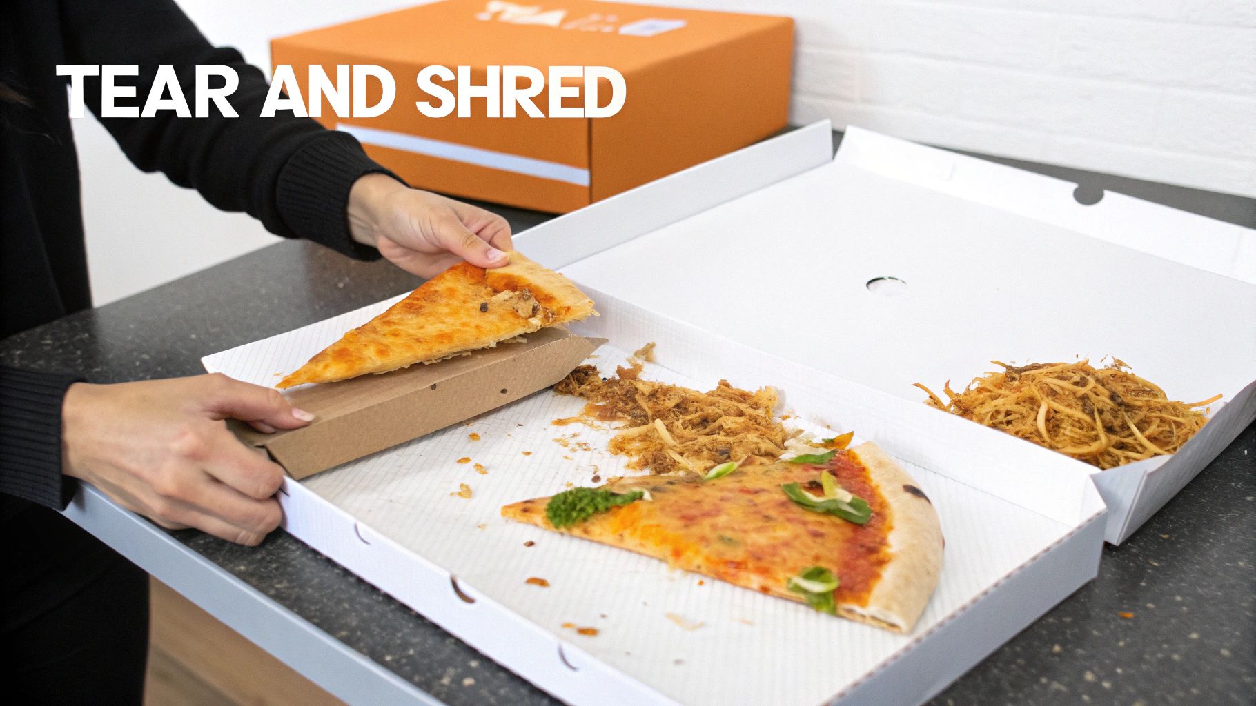 A person tearing a pizza box in half over a compost bin, separating the clean top from the greasy bottom.