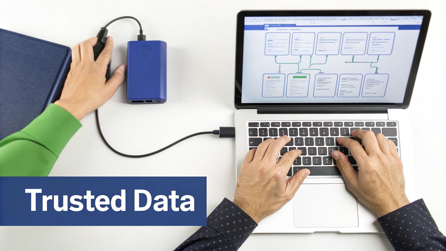 Overhead view of hands using a laptop displaying a data flowchart, connected to a blue power bank, with a 'Trusted Data' banner.