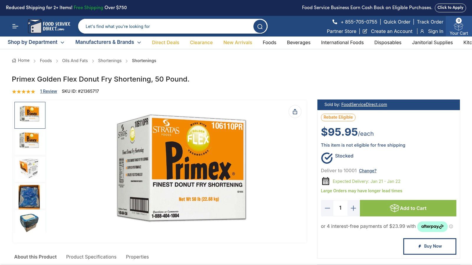 A large 50-pound box of donut frying shortening sits next to freshly made donuts on a wire rack.