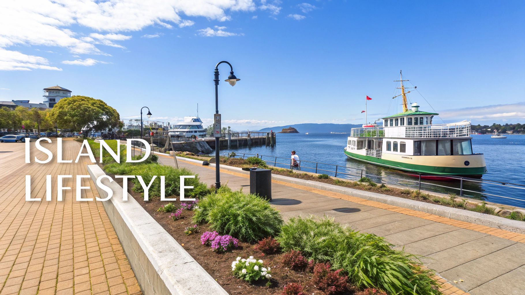 Scenic waterfront promenade with ferry boat, lamp posts, and mountain views in coastal city