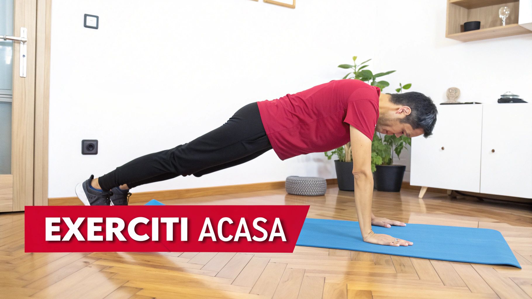 Bărbat într-un tricou roșu și pantaloni negri executând exercițiul planșă pe o saltea de yoga albastră.