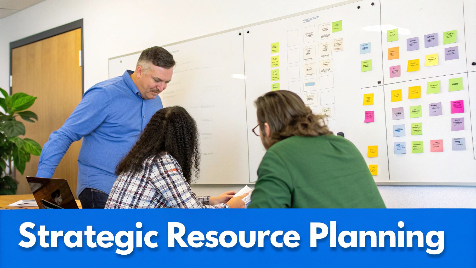 Three colleagues collaborate in an office, reviewing documents and a whiteboard with sticky notes.
