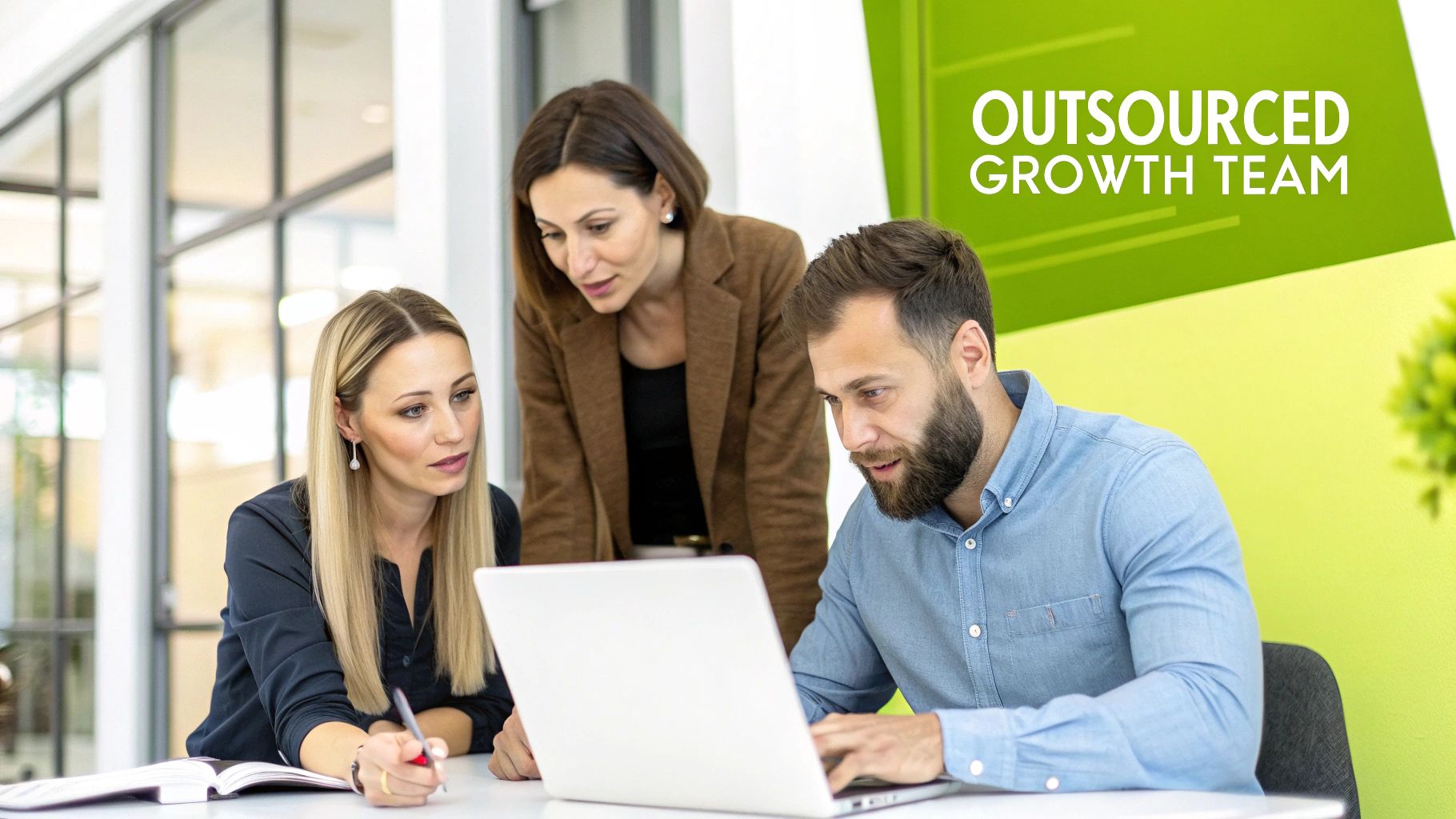 Three business professionals collaborating on a laptop in a modern office, forming an outsourced growth team.