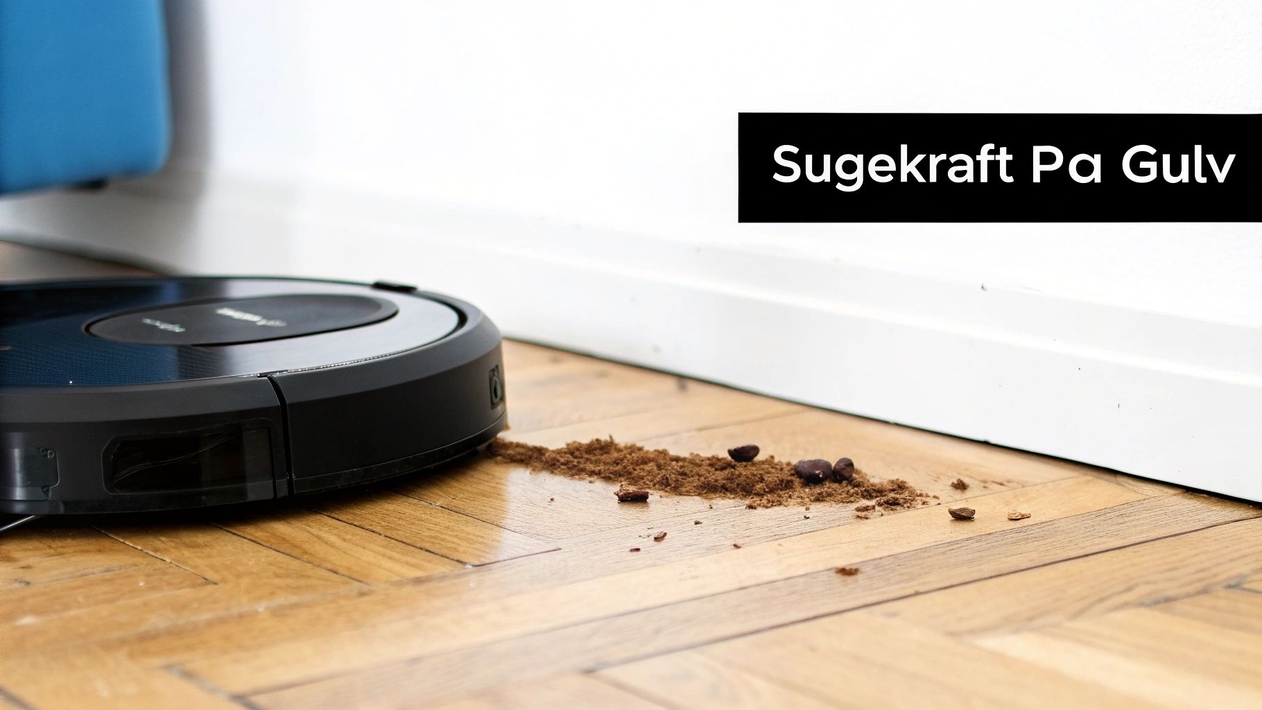 En robotstøvsuger viser sugekraft på et tregulv med skitt og kaffebønner.