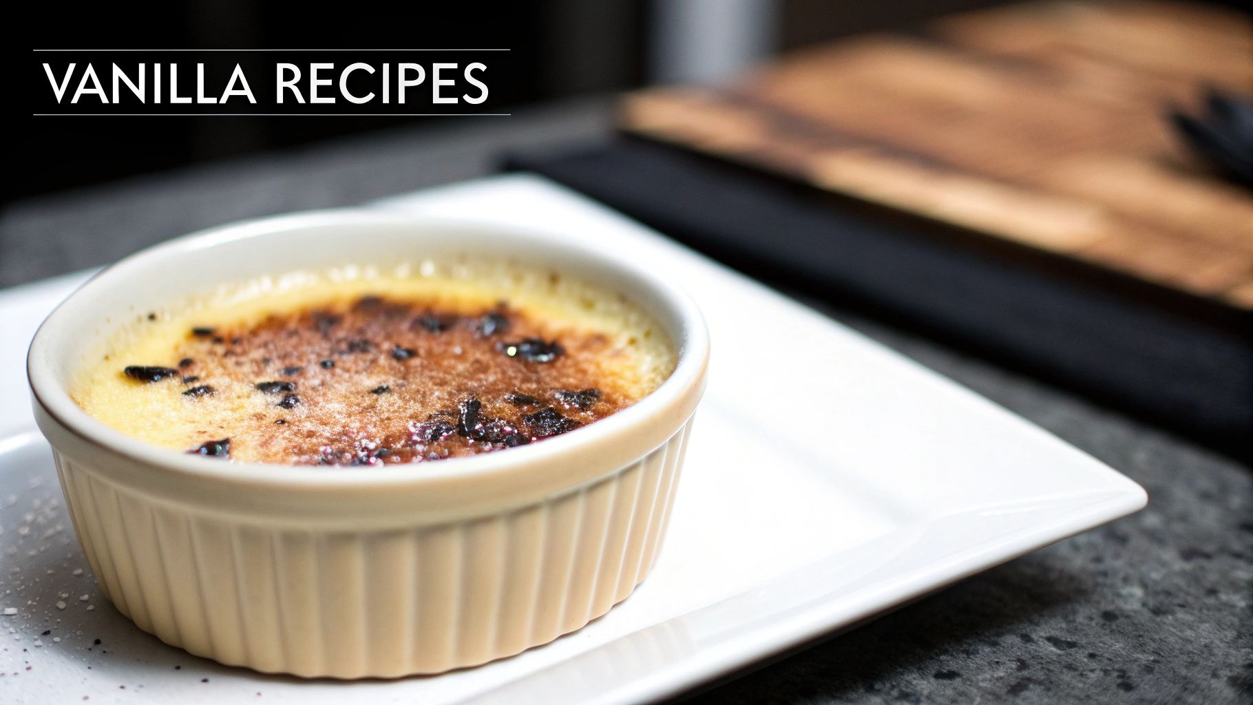 Vanilla crème brûlée dessert with caramelized sugar top in white ramekin on white plate
