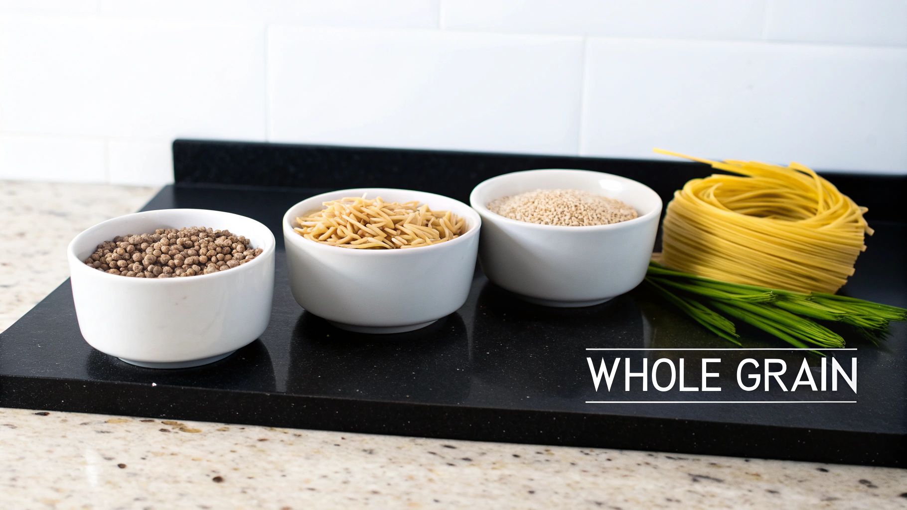 Bowls of various whole grains, including pasta and quinoa, displayed on a black kitchen counter.