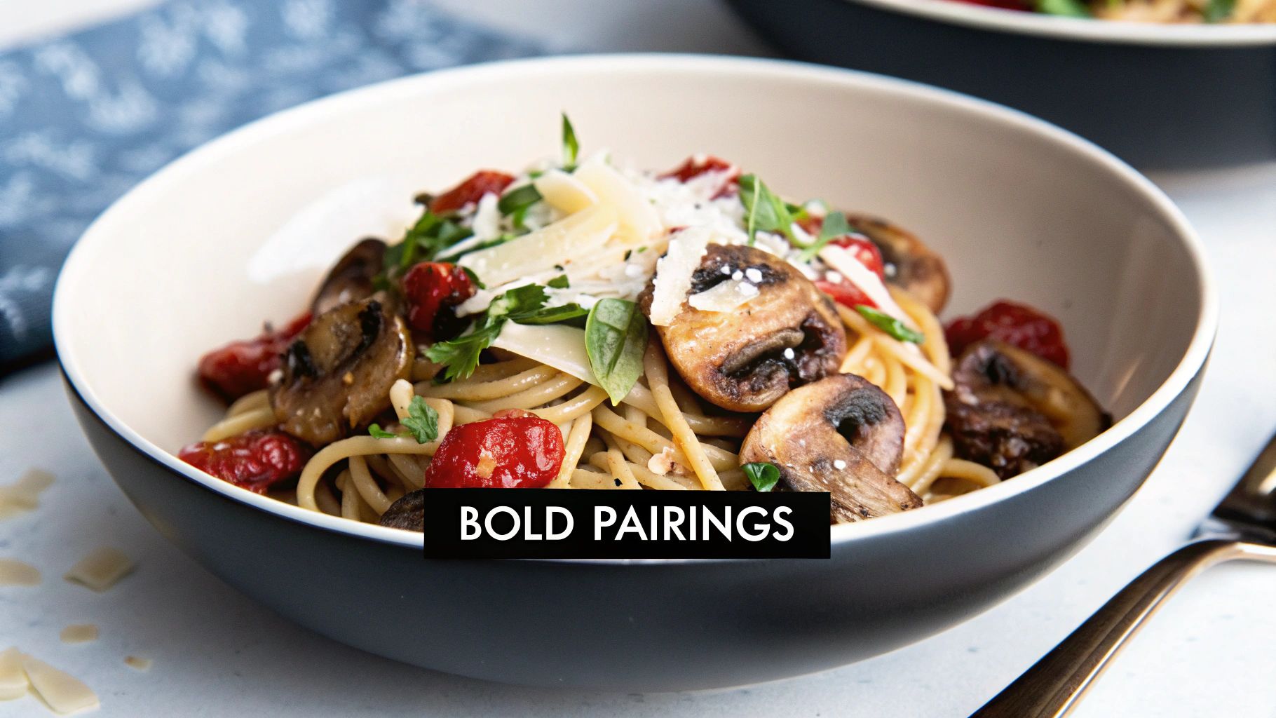 A delicious bowl of pasta with sautéed mushrooms, cherry tomatoes, fresh herbs, and parmesan cheese.