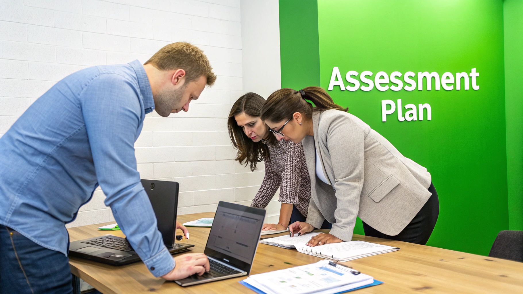 Three business professionals collaborating around laptops and documents, with an 'Assessment Plan' sign.