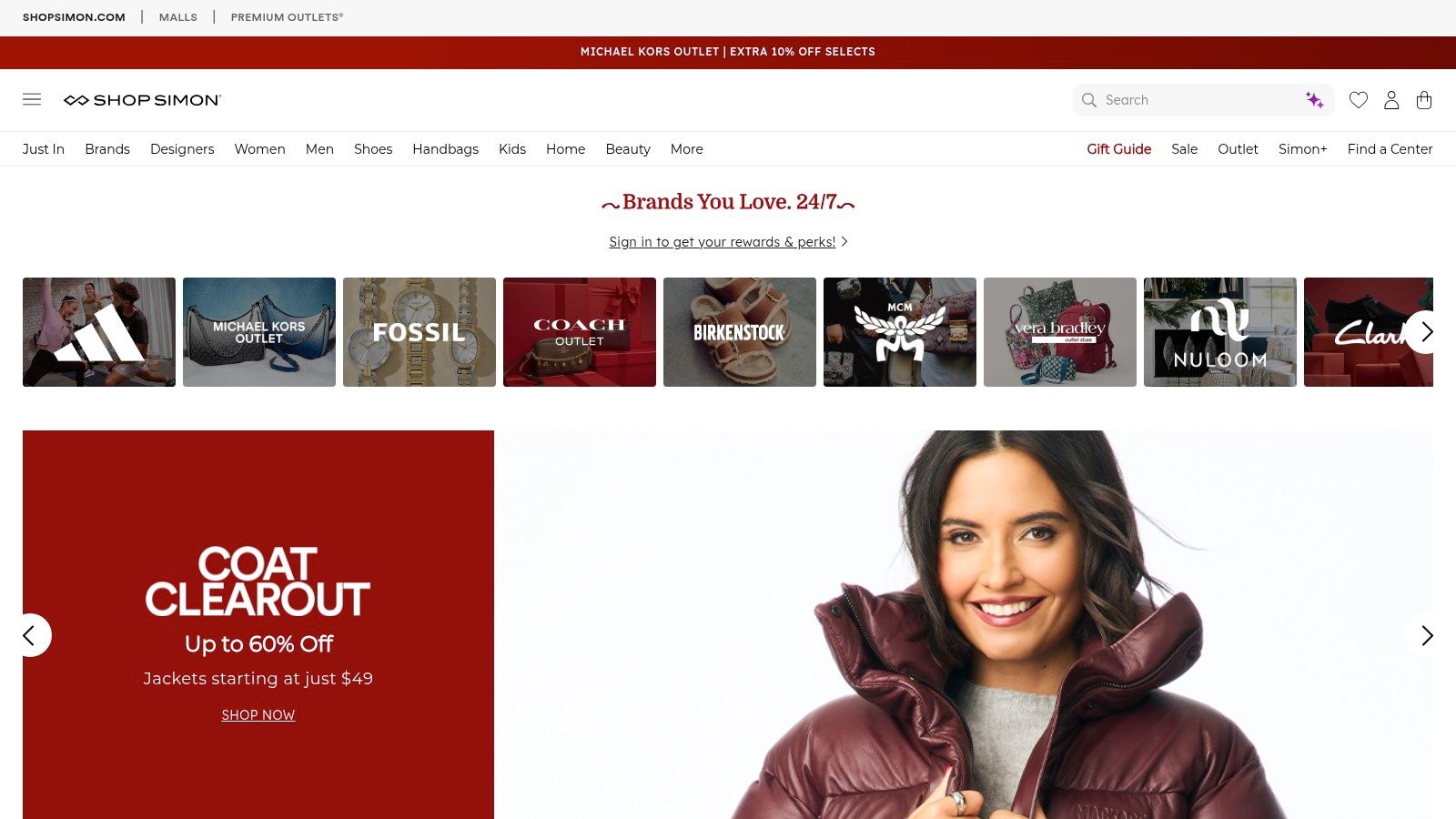 A woman sitting on a couch, smiling as she shops online on her laptop with her credit card, illustrating the convenience of online outlet shopping.