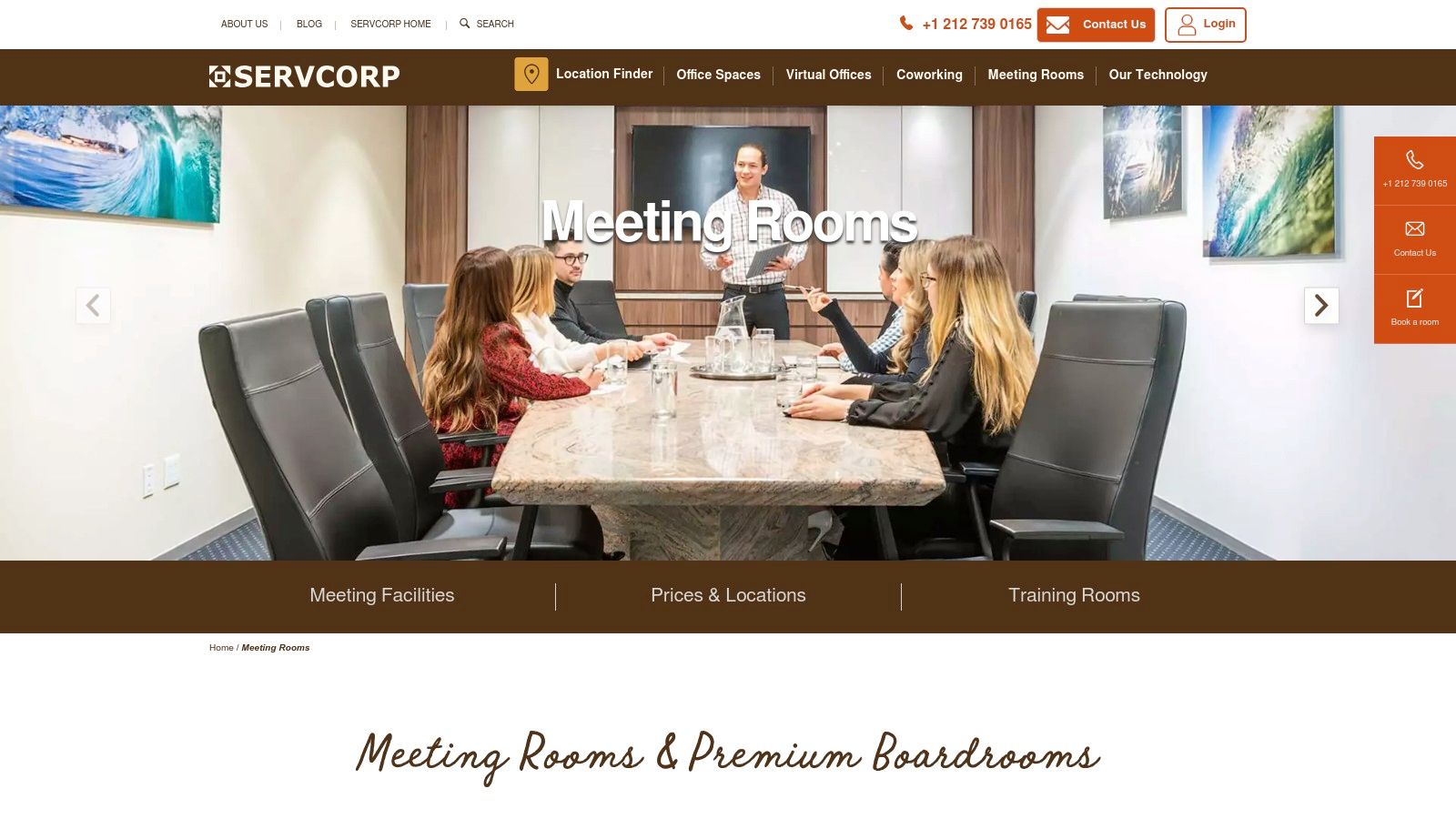 A professional boardroom meeting with attendees sitting around a large table, engaged in a discussion.