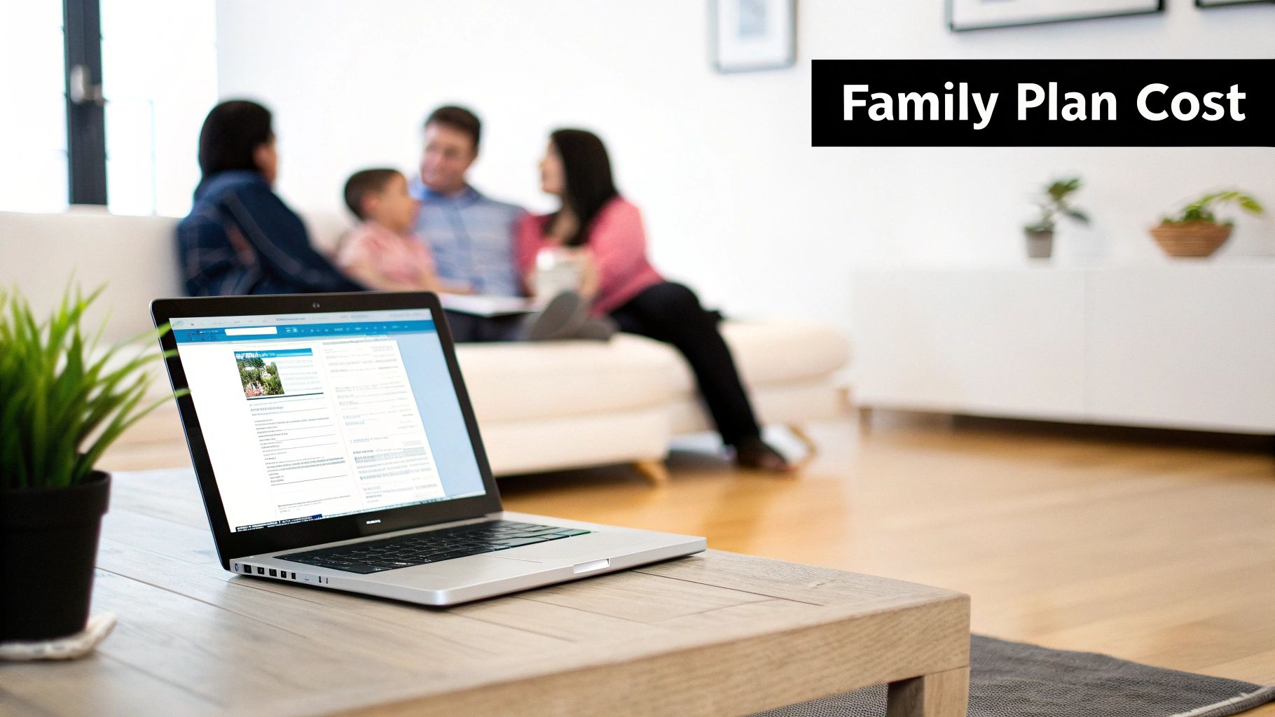 Laptop on a wooden table with a blurred family in the background, researching family plan costs.