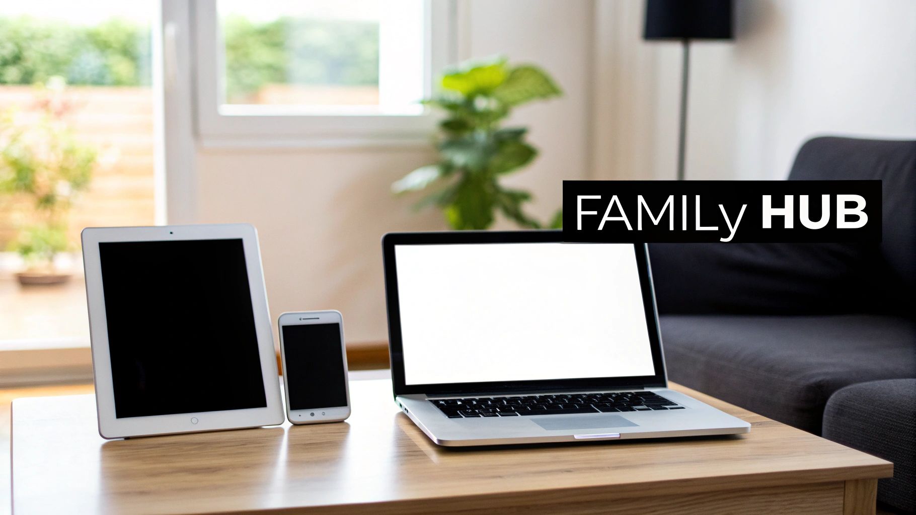 Electronic devices including a tablet, smartphone, and laptop are displayed on a wooden table.