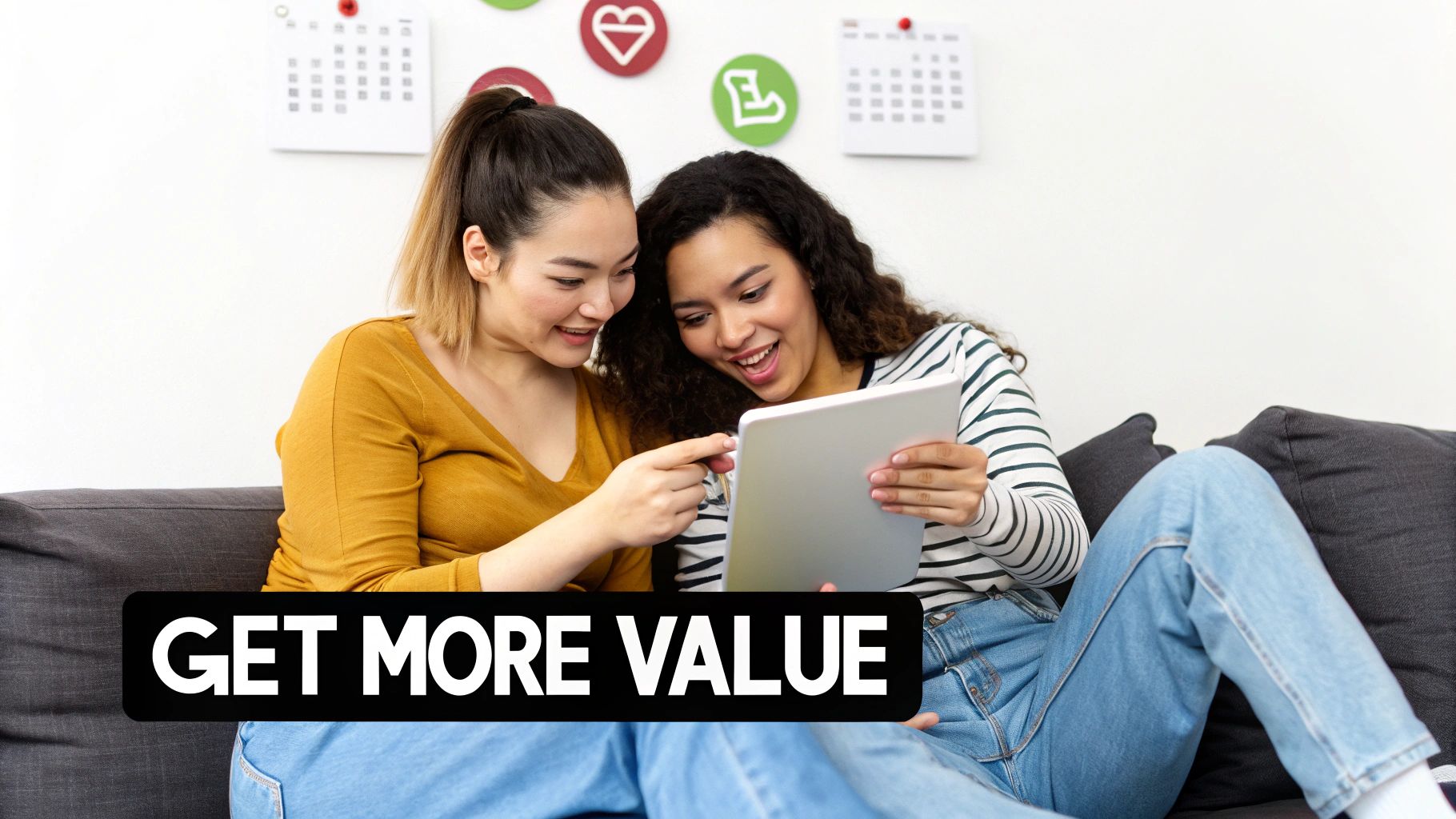 Two smiling young women sharing a tablet on a couch, with 'GET MORE VALUE' text.