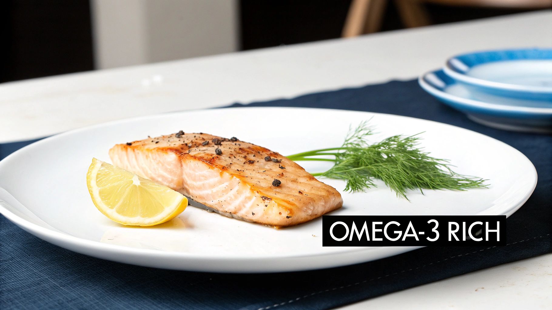 A grilled salmon fillet seasoned with pepper, lemon, and dill on a white plate, labeled 'OMEGA-3 RICH'.