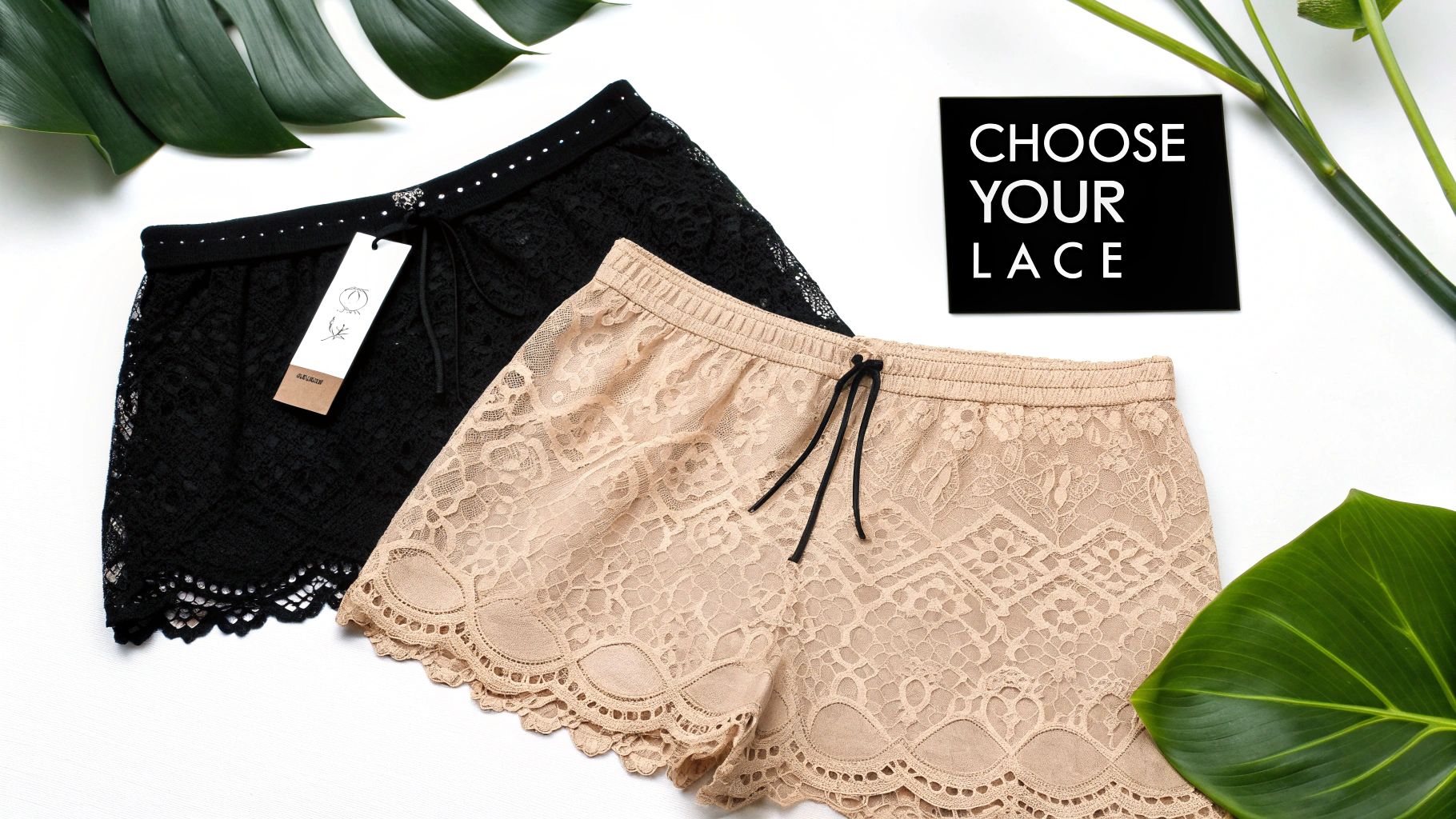 Two pairs of elegant lace shorts, one black and one beige, displayed with green leaves and a sign.