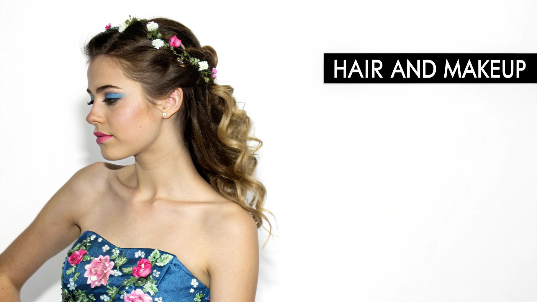 Woman in floral blue dress with elegant updo hairstyle, flower crown and colorful makeup