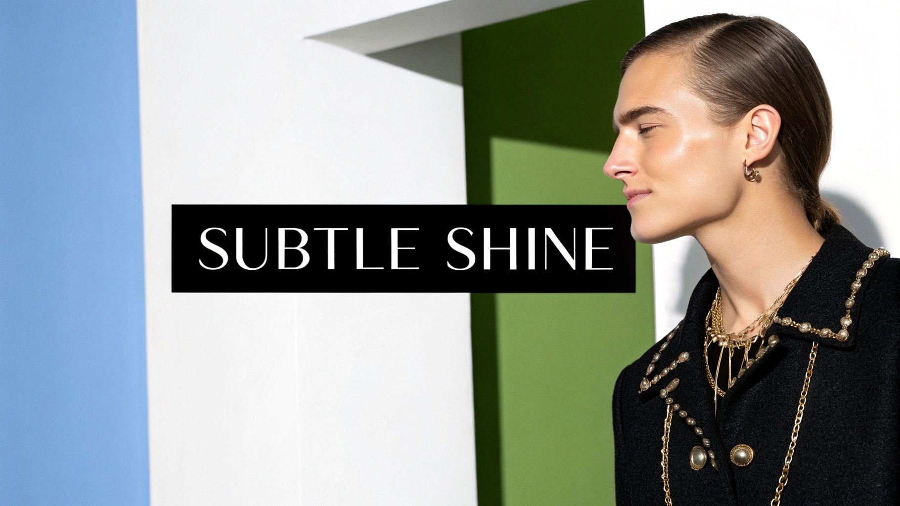 Profile shot of a model with glowing skin and sleek hair, wearing a stylish black coat and gold jewelry.